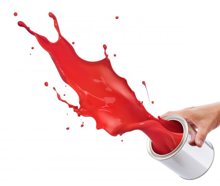 pouring red paint from its bucket creating splash